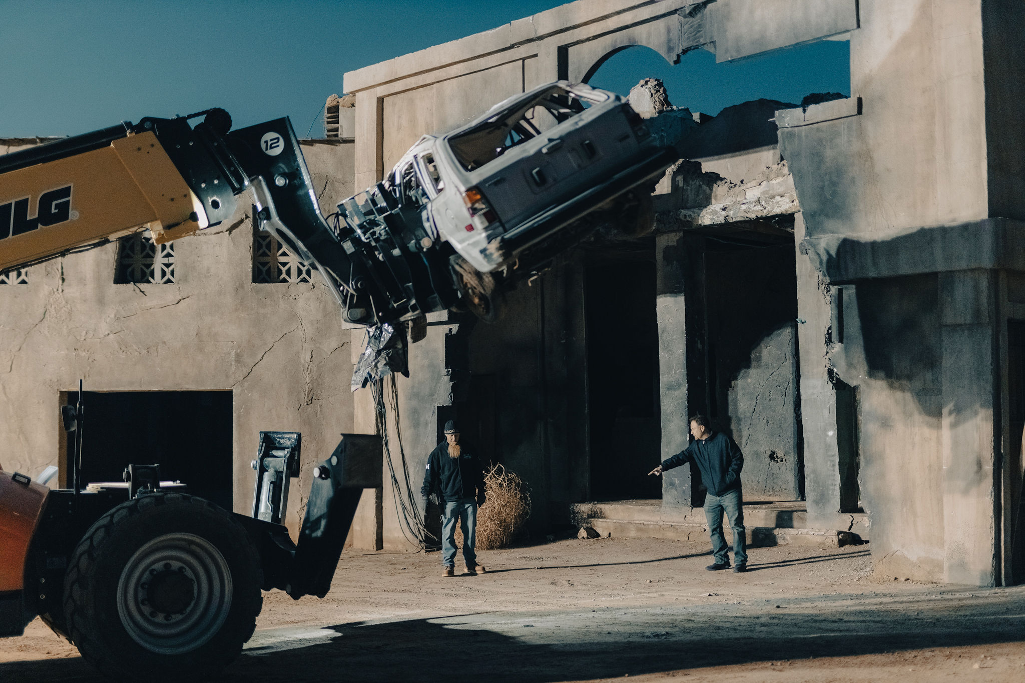 A large lighting rig being positioned outside the period film set