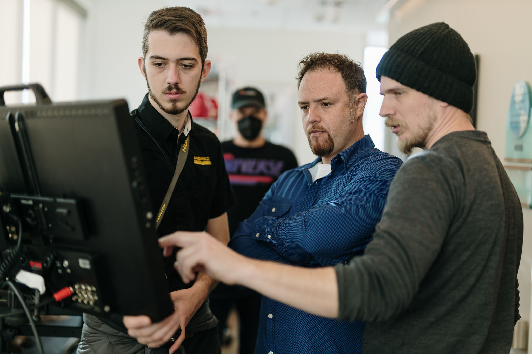 Wayne reviewing a shot with two members of the production team