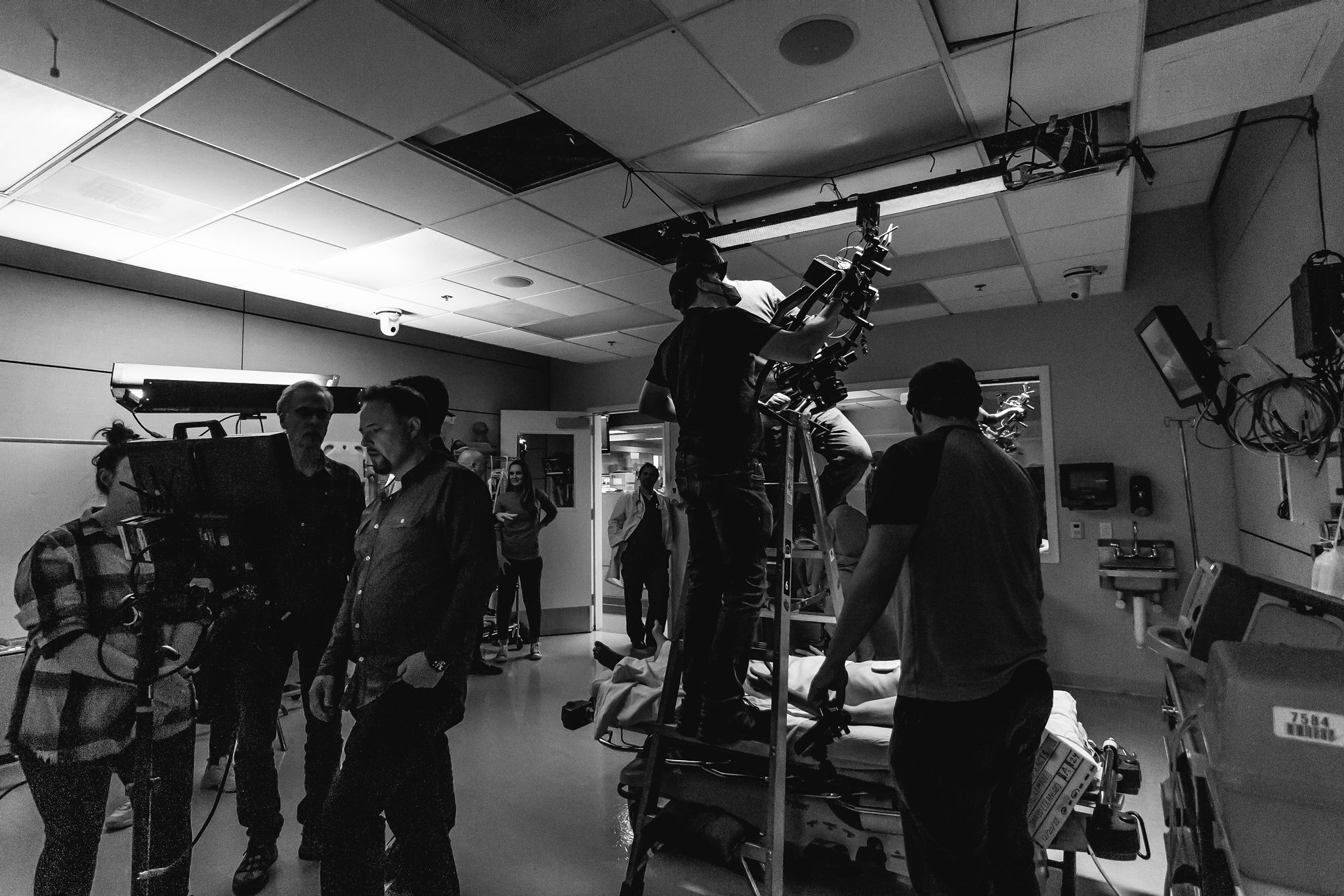 Black-and-white behind-the-scenes photograph of a cinema crew and camera inside an interior set