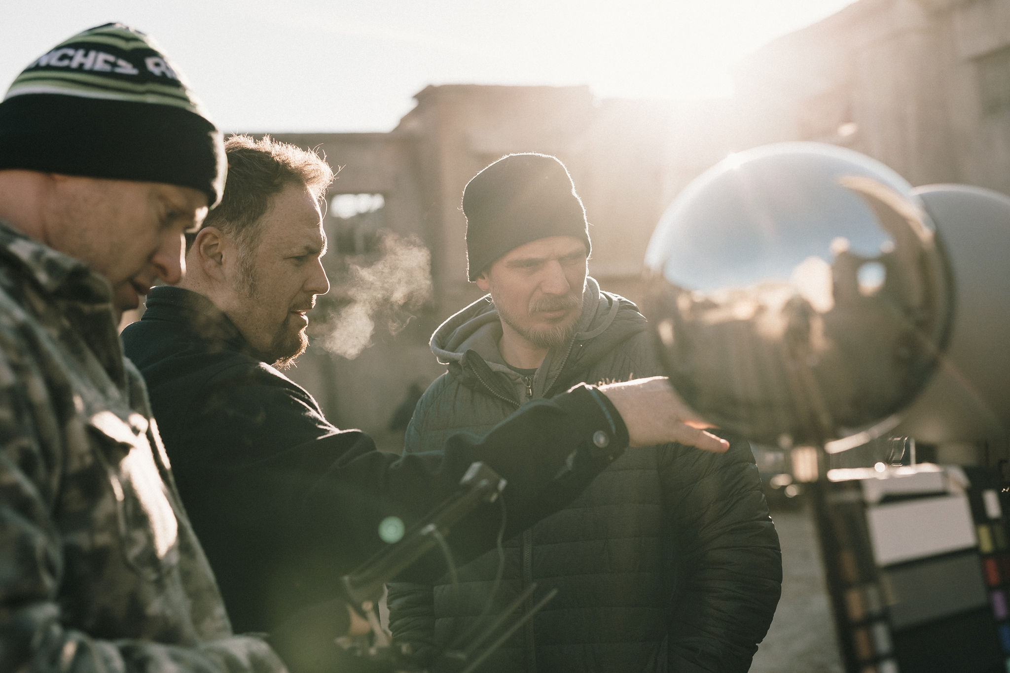 Wayne and the crew studying a reflective lighting reference sphere on location